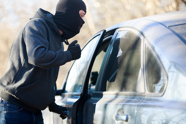 Thief stealing automobile car at daylight street in city